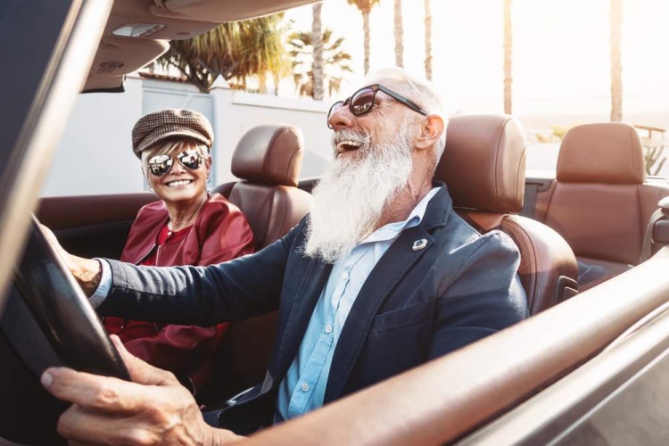 Pareja adulta divirtiéndose en un nuevo auto convertible - Personas maduras durante vacaciones de viaje por carretera - Estilo de vida de los ancianos.