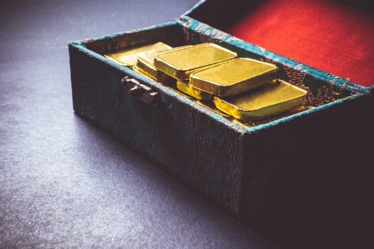 Barras de oro puro en una maleta.