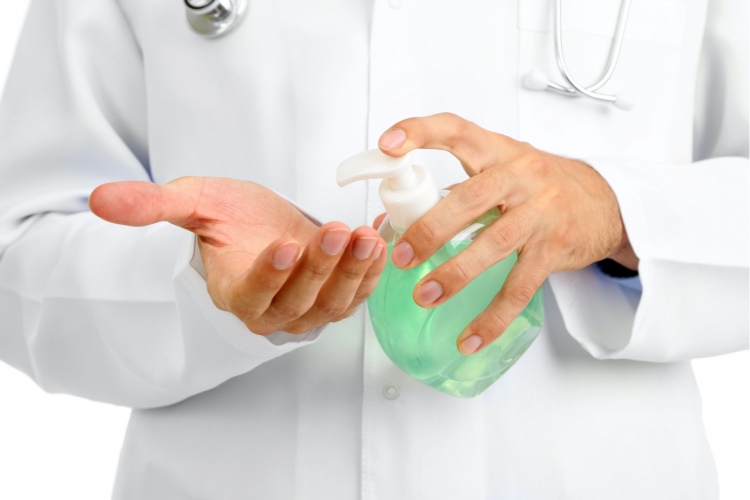 Doctor usando dispensador de desinfectante para manos