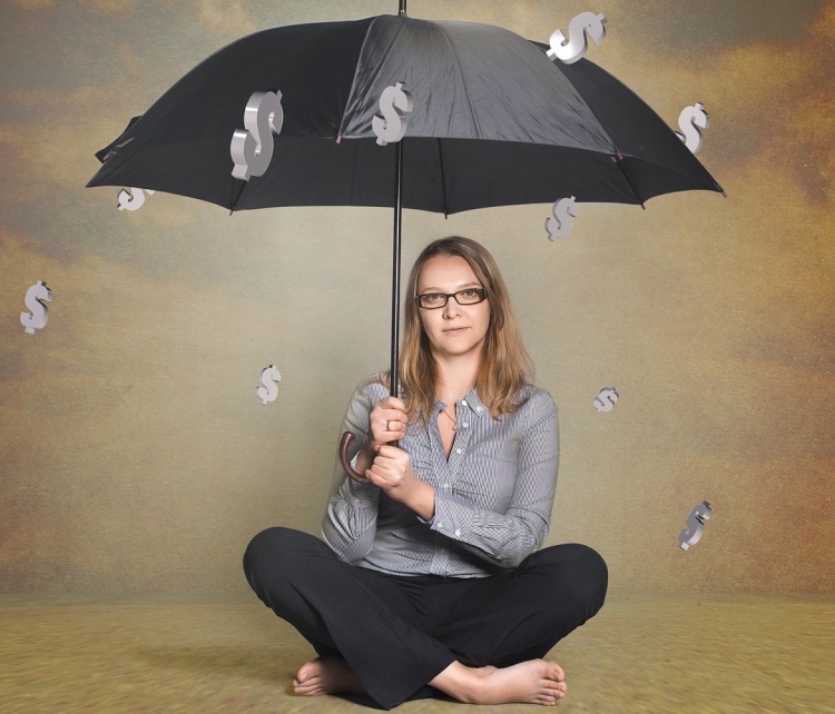 Mujer con sombrilla mientras llueve dinero.
