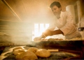 En una panadería artesanal, un panadero prepara la masa de pan.