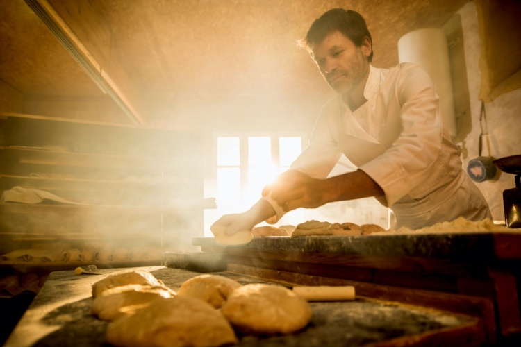 En una panadería artesanal, un panadero prepara la masa de pan.