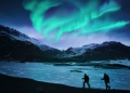 Excursionistas bajo la aurora boreal en Islandia.
