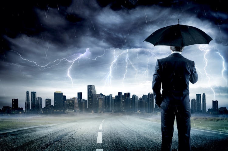 Empresario con paraguas mirando la tormenta sobre la ciudad