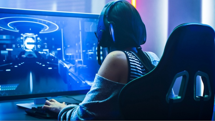 Chica Pro Gamer juega unvideojuego en su computadora personal.