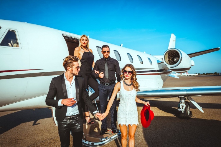 Dos parejas ricas y famosas saliendo de un avión privado.