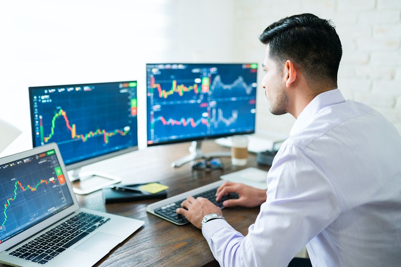 Hombre comprando acciones desde la computadora de su casa.