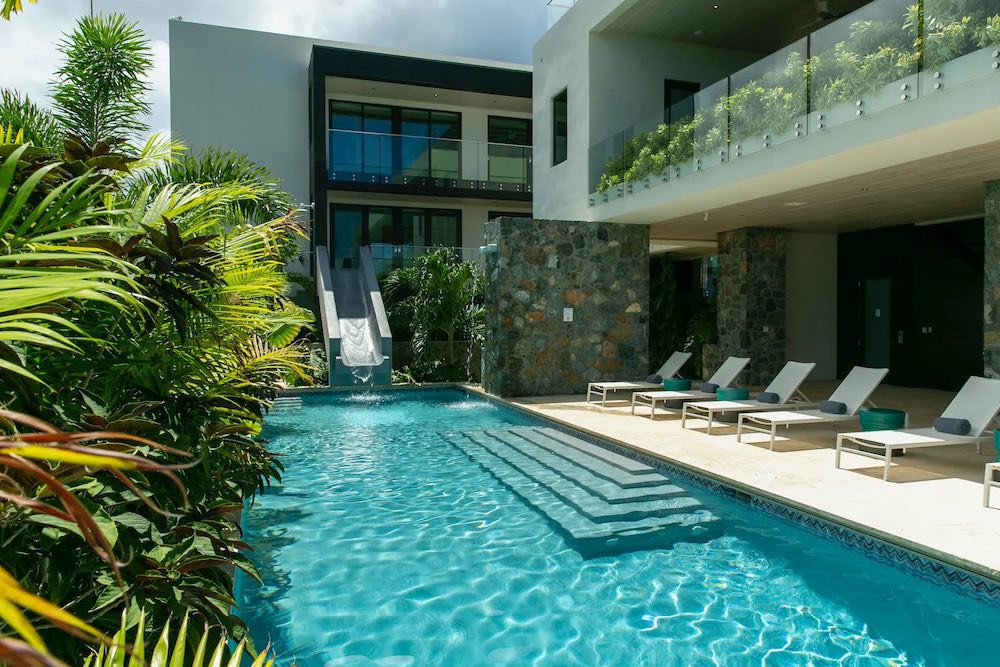 La propiedad cuenta con un diseño moderno y tropical, en tonos gris, beige y blanco, con un enfoque minimalista
