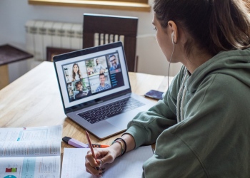 Mujer joven en casa durante la pandemia en un curso en línea (e-learning).