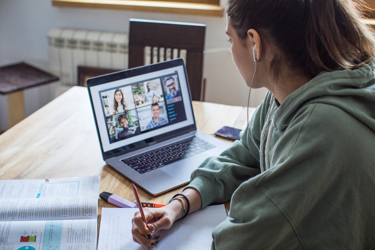 Mujer joven en casa durante la pandemia en un curso en línea (e-learning).