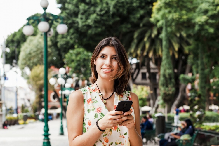 Mujer hispana enviando mensajes de texto con su teléfono. mujer mexicana en México.