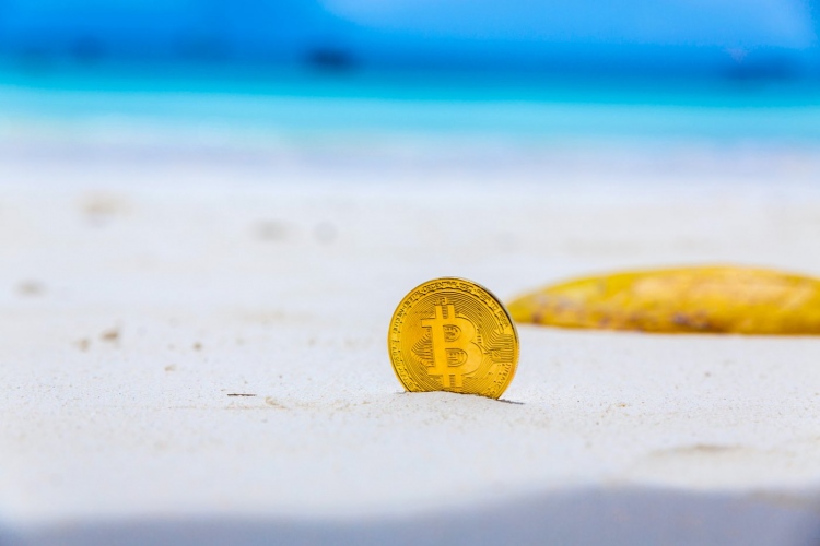 Moneda de Bitcoin en la playa.