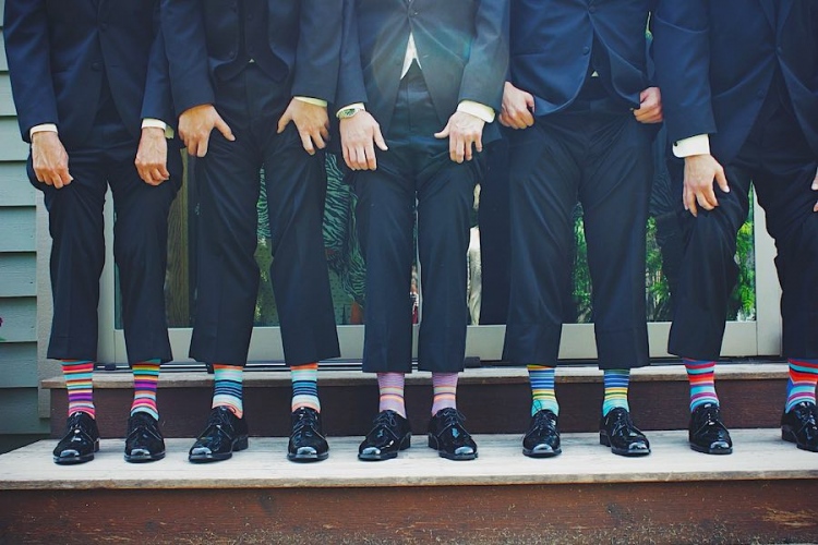 Hombres en trajes con calcetines de colores.
