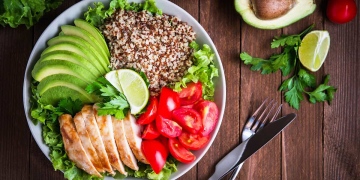 Ensalada saludable con quinoa, tomates, pollo, aguacate y verduras mixtas. Comida y salud.