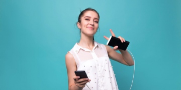 Chica con smartphone y Power bank cargando su teléfono inteligente.