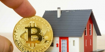 Moneda Bitcoin y un modelo de casa.