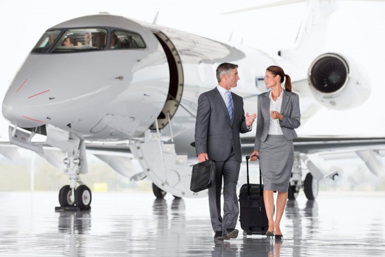 Hombre y mujer (viajeros) de negocios hablando mientras se alejan del avión.