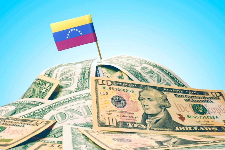 La bandera nacional de Venezuela clavada en un montón de dólares americanos.