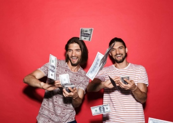 Dos jóvenes lanzando dinero en efectivo.