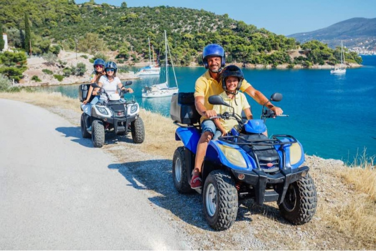 Familia de vacaciones montando en cuadriciclo en una isla de Grecia.