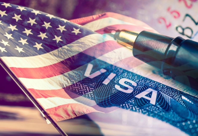 Visa de los Estados Unidos con la bandera americana en el fondo.