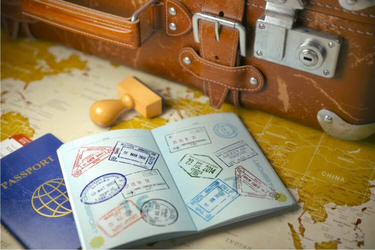 Maleta vieja con pasaporte abierto con sellos de visa.